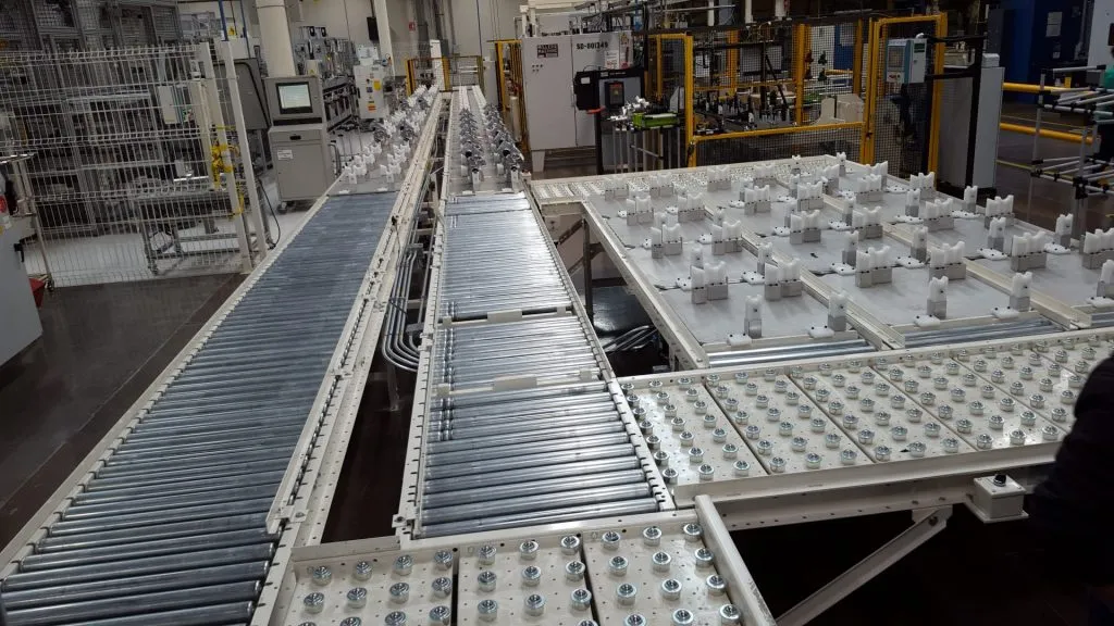 Filled trays moving down a roller conveyor
