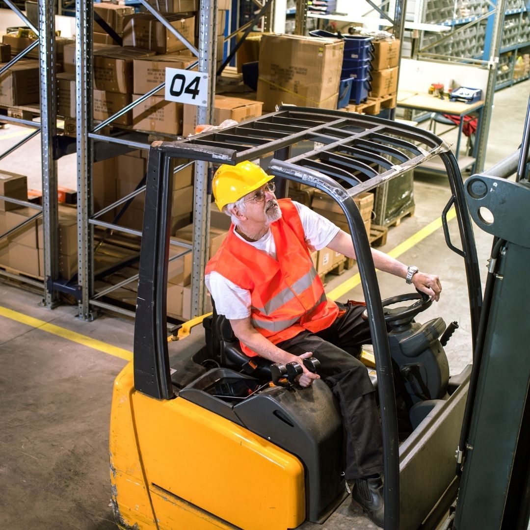 Forklift operator moving material in a warehouse