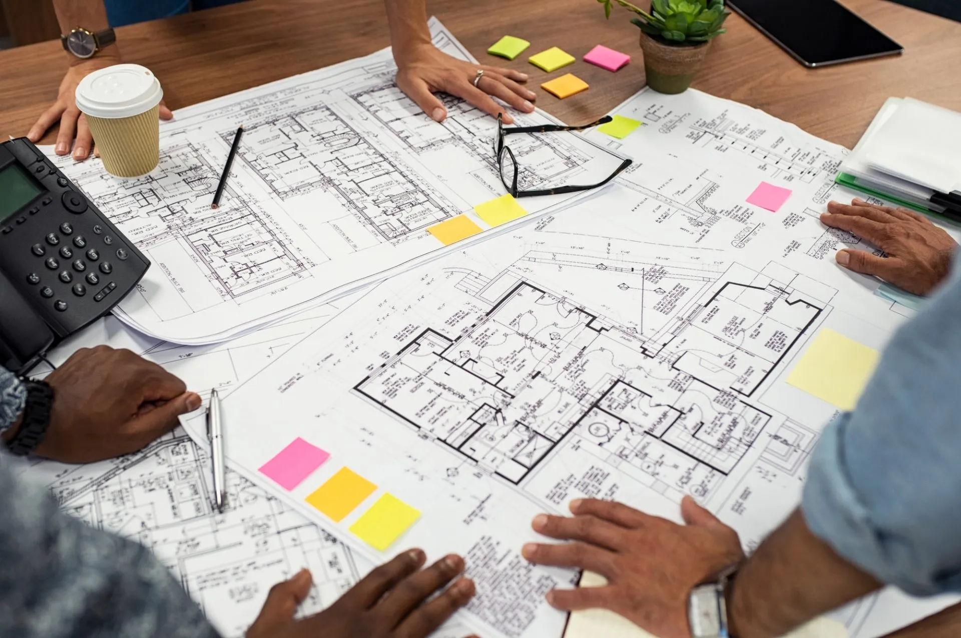 Engineers working over facility layout blueprints