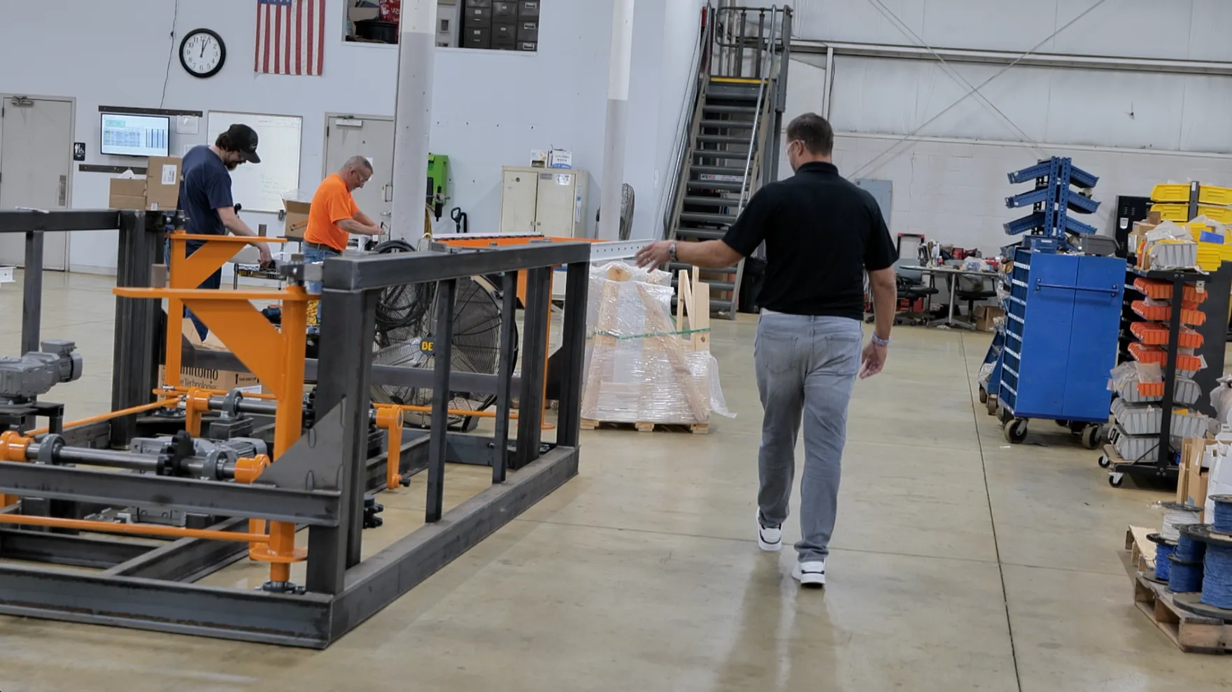 Technician walking a warehouse aisle past material handling equipment