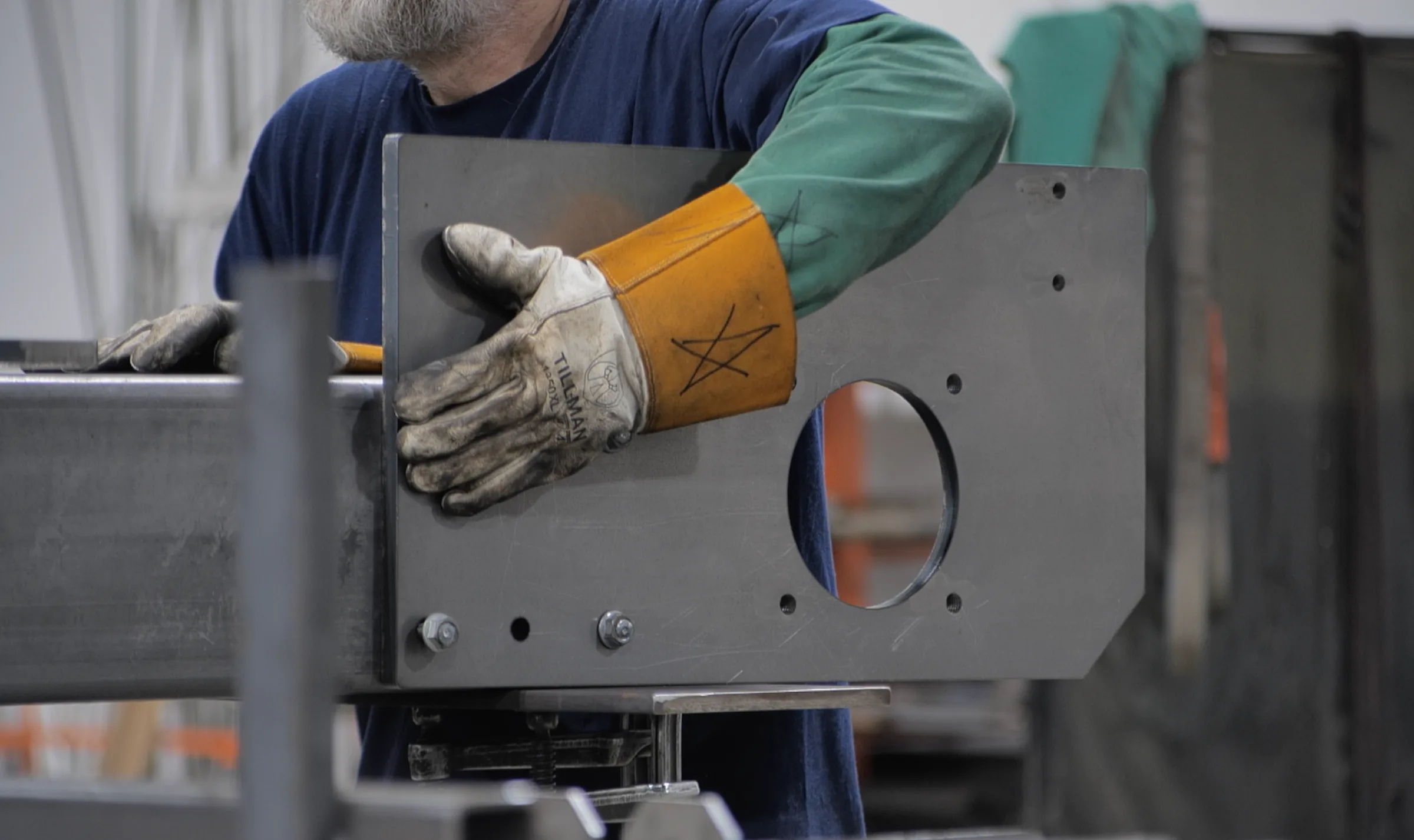 Gloved hands assembling a fabricated metal panel
